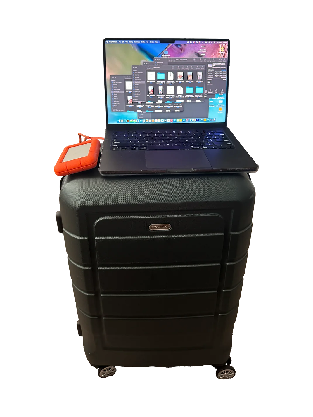 Suitcase with a computer and ssd on top of it.